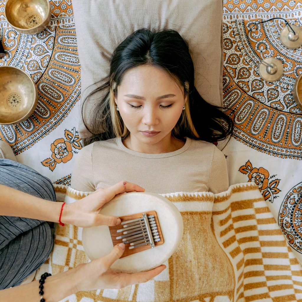 Femme allongée en massage sonore, entourée de différents instruments